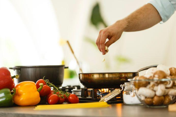 a man cooking by using stainless steel cookware